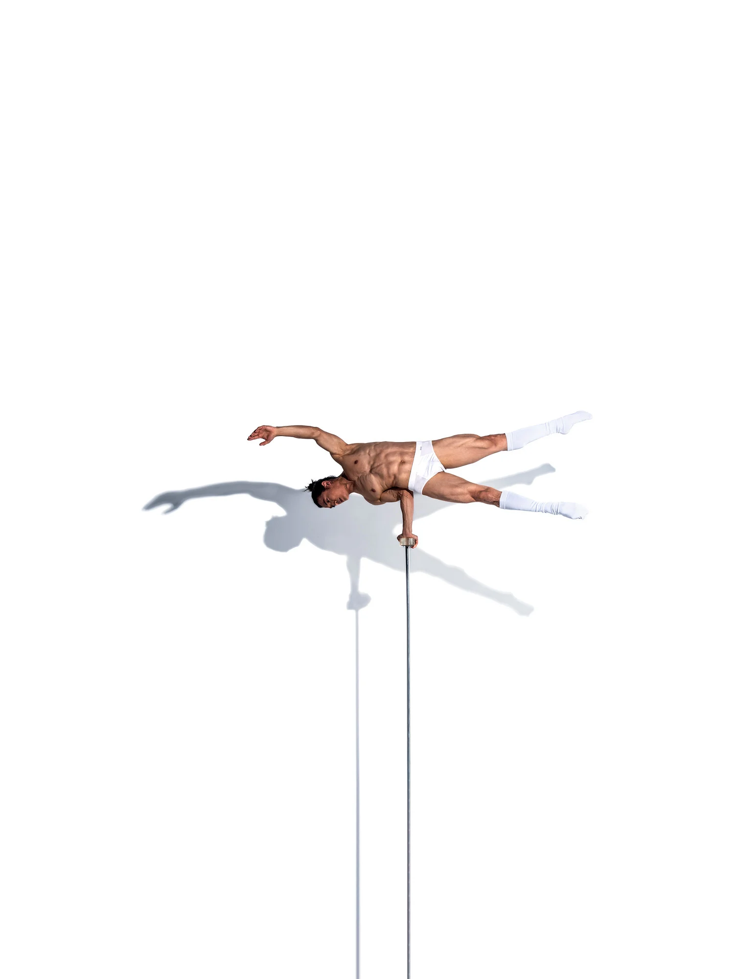 Ochir in a sculptural hand balancing pose against white