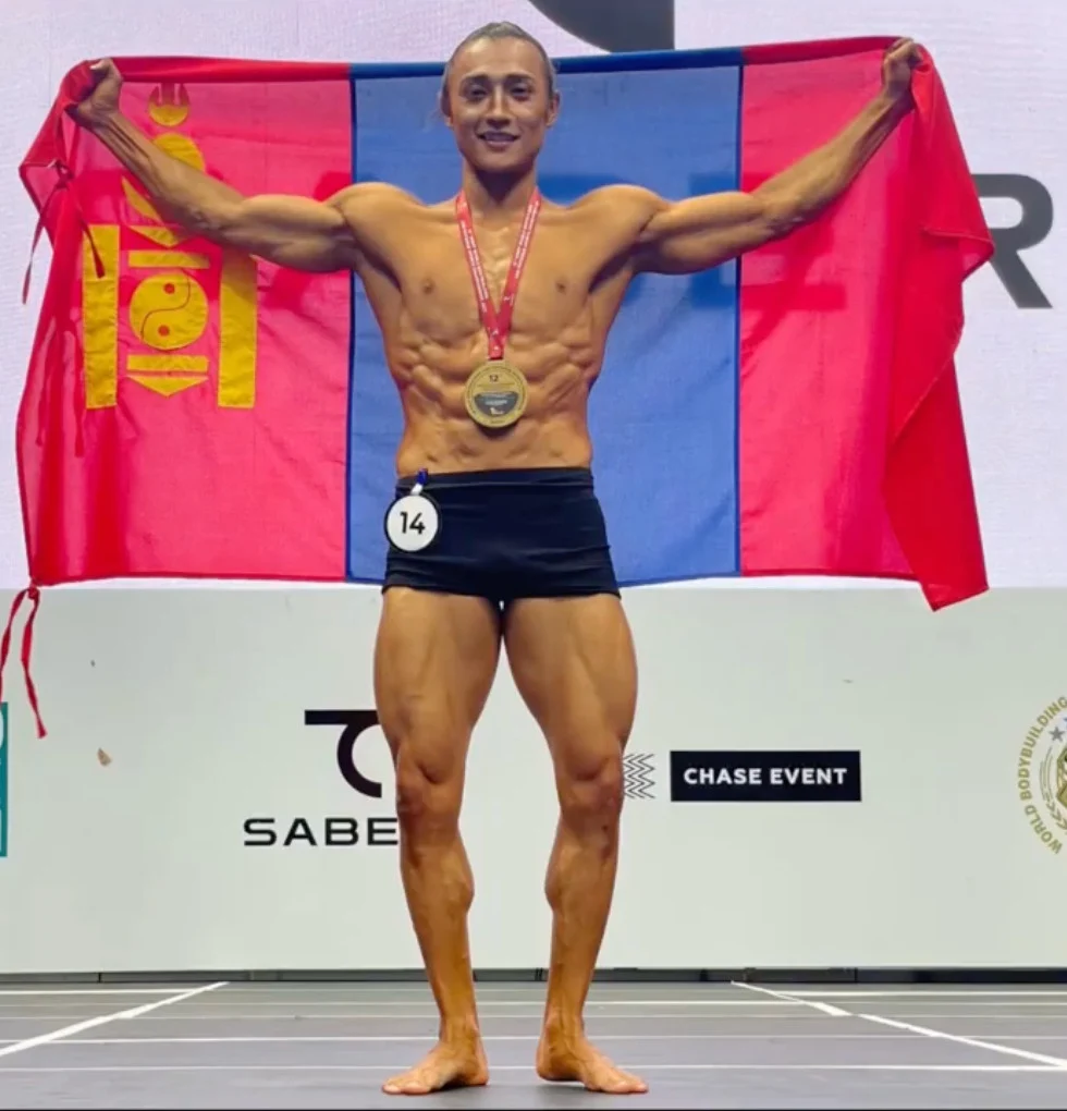 Ochir holding the Mongolian flag after his fitness physique world championship victory