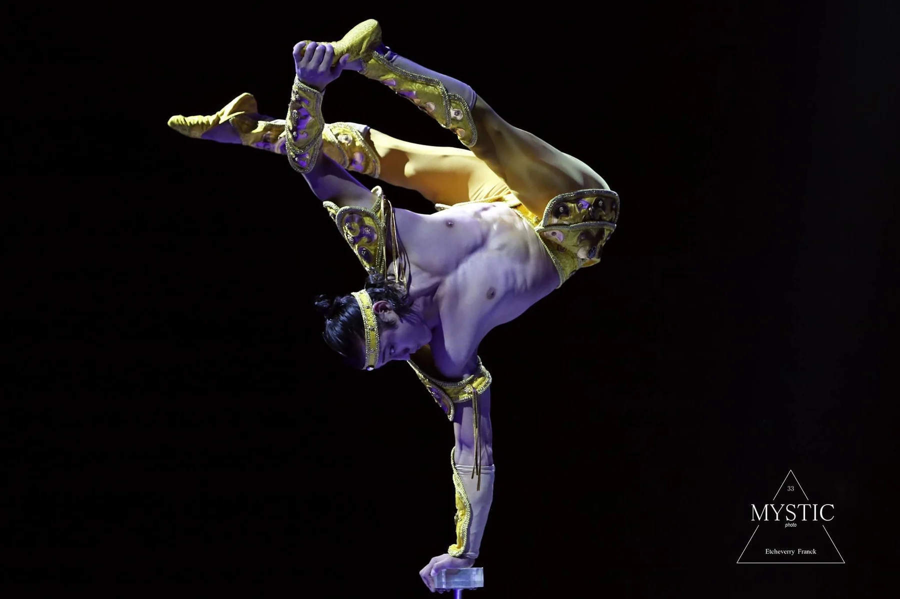 Ochir holding a deep contortion balance on stage