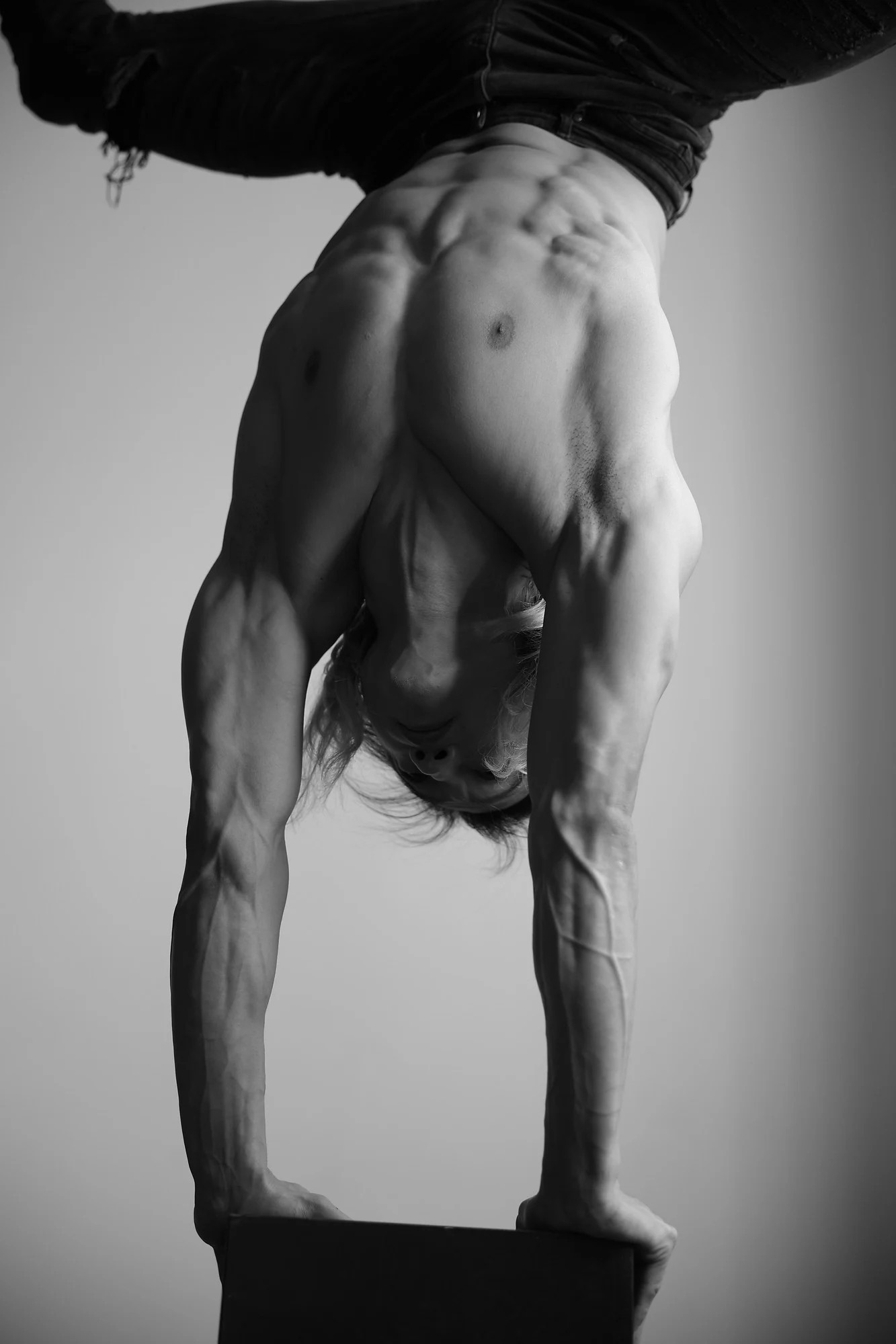Black and white photograph of Ochir hand balancing in the studio