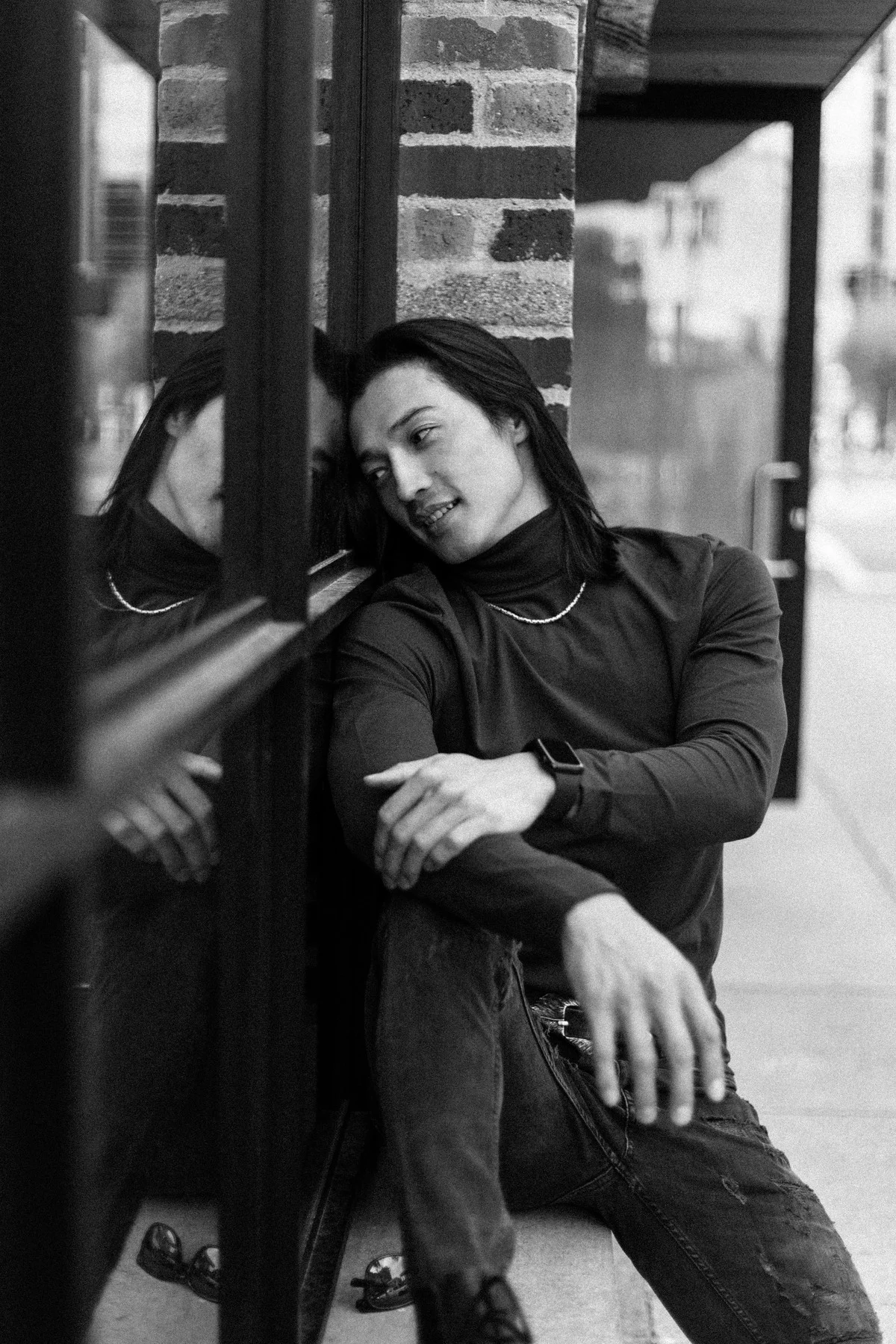 Black and white portrait of Ochir seated beside a window