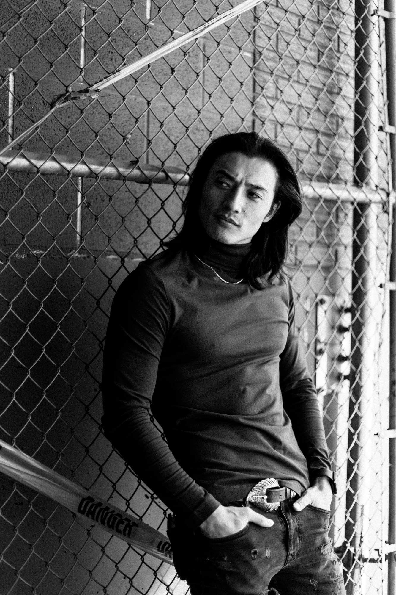 Black and white portrait of Ochir beside a wire fence