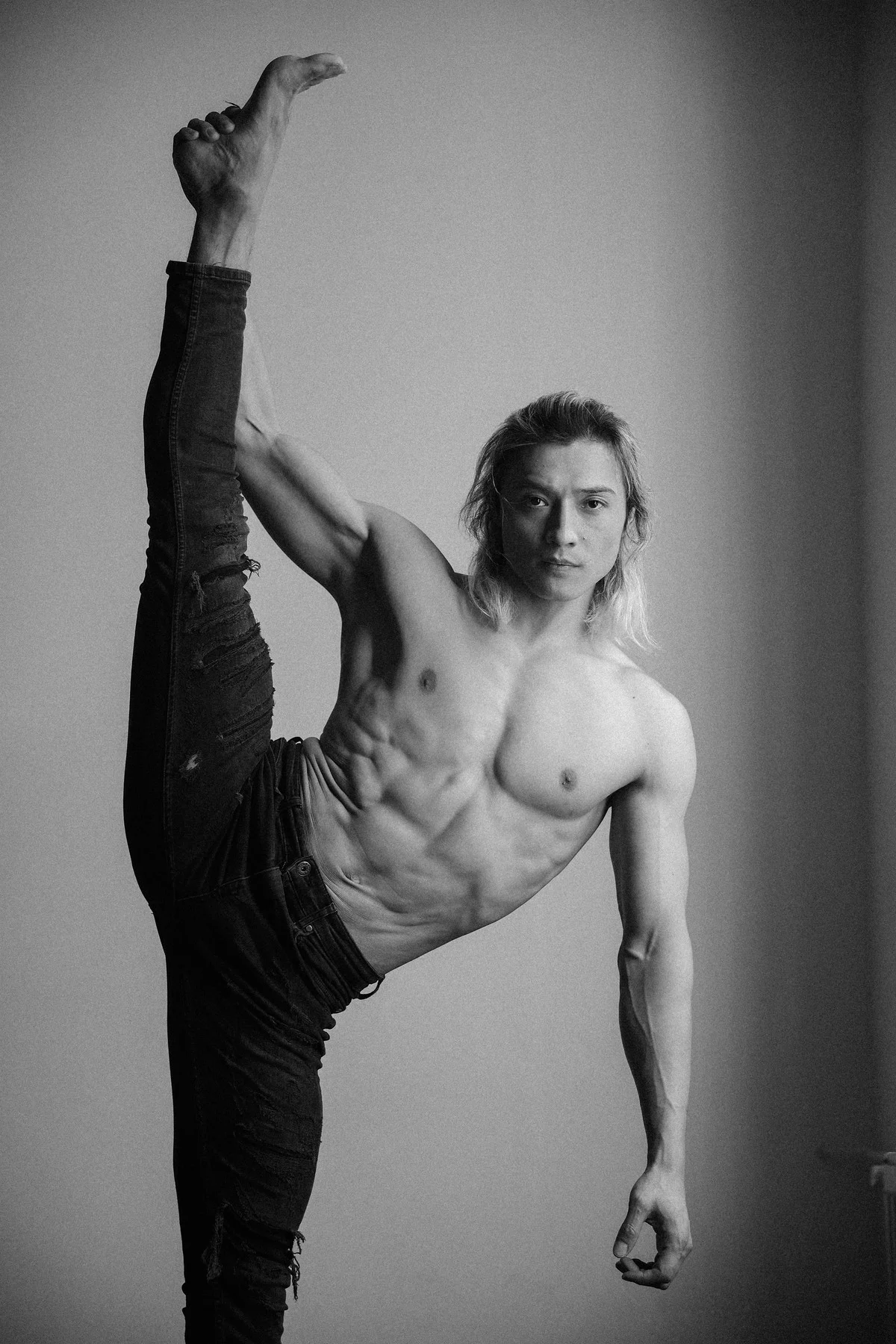 Black and white studio portrait of Ochir with one arm raised